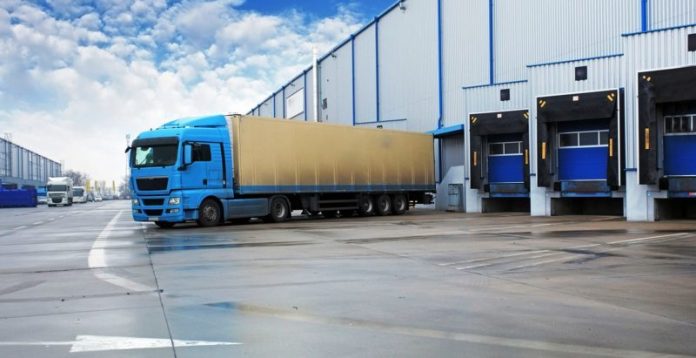 Unloading cargo truck at warehouse building