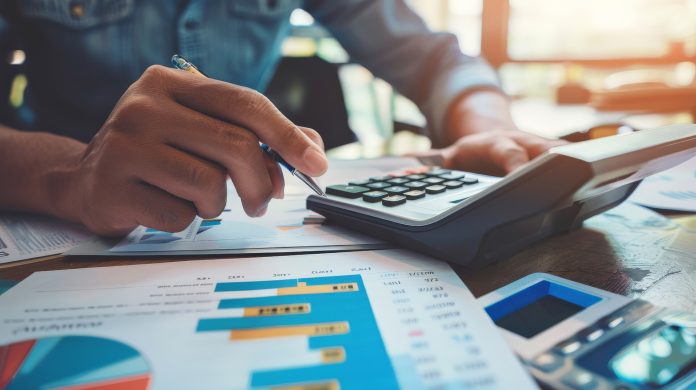Person using a financial calculator, planning their savings and investments